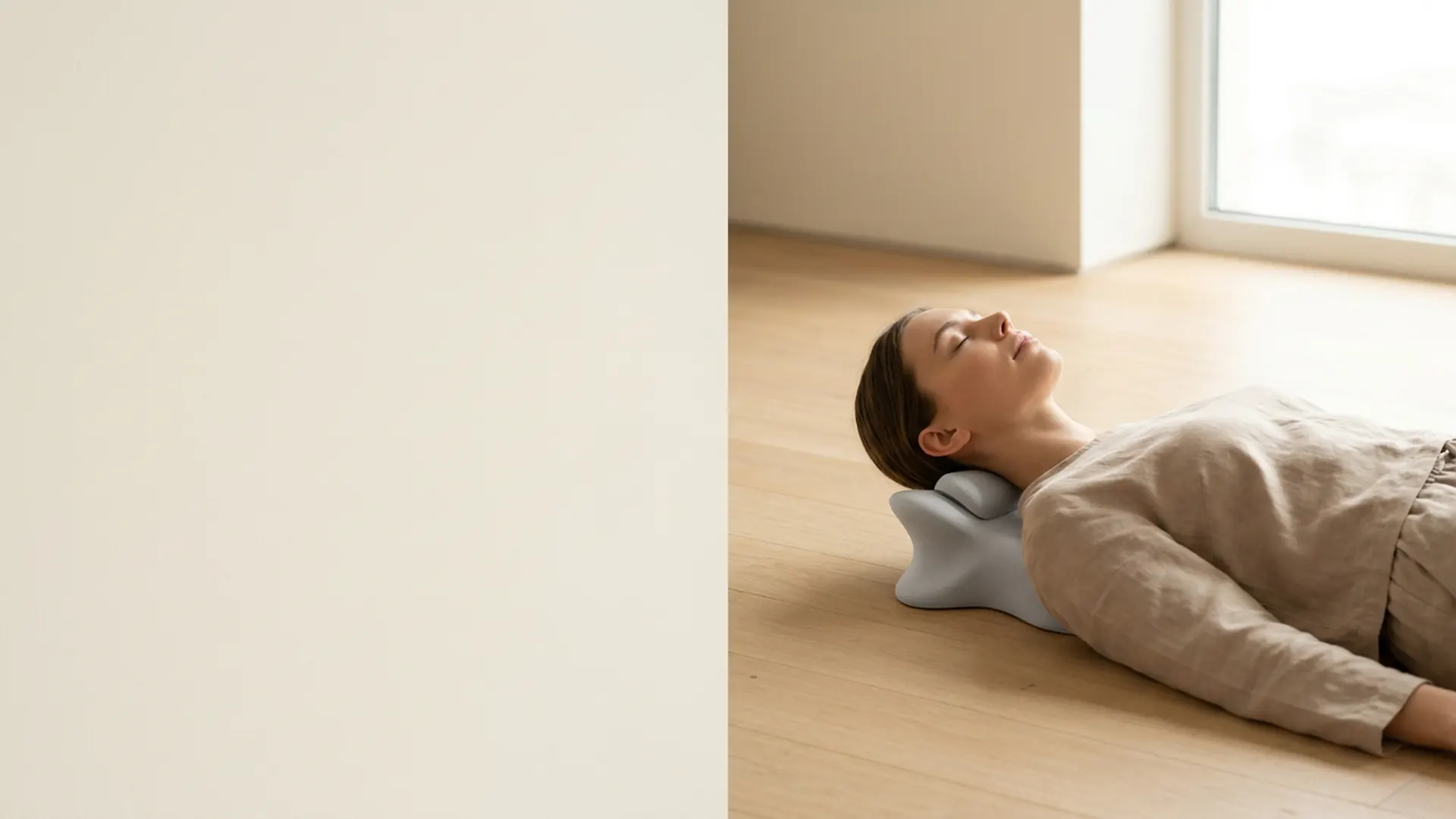 A calm woman resting her neck on the sage-green KSDM cervical stretcher in a sunlit minimalist room